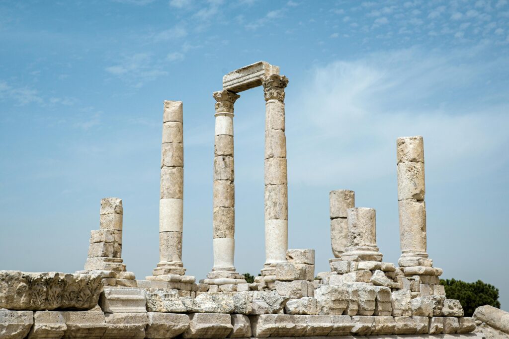 View of the ancient Roman Temple of Hercules ruins in Amman, Jordan, under a clear blue sky.